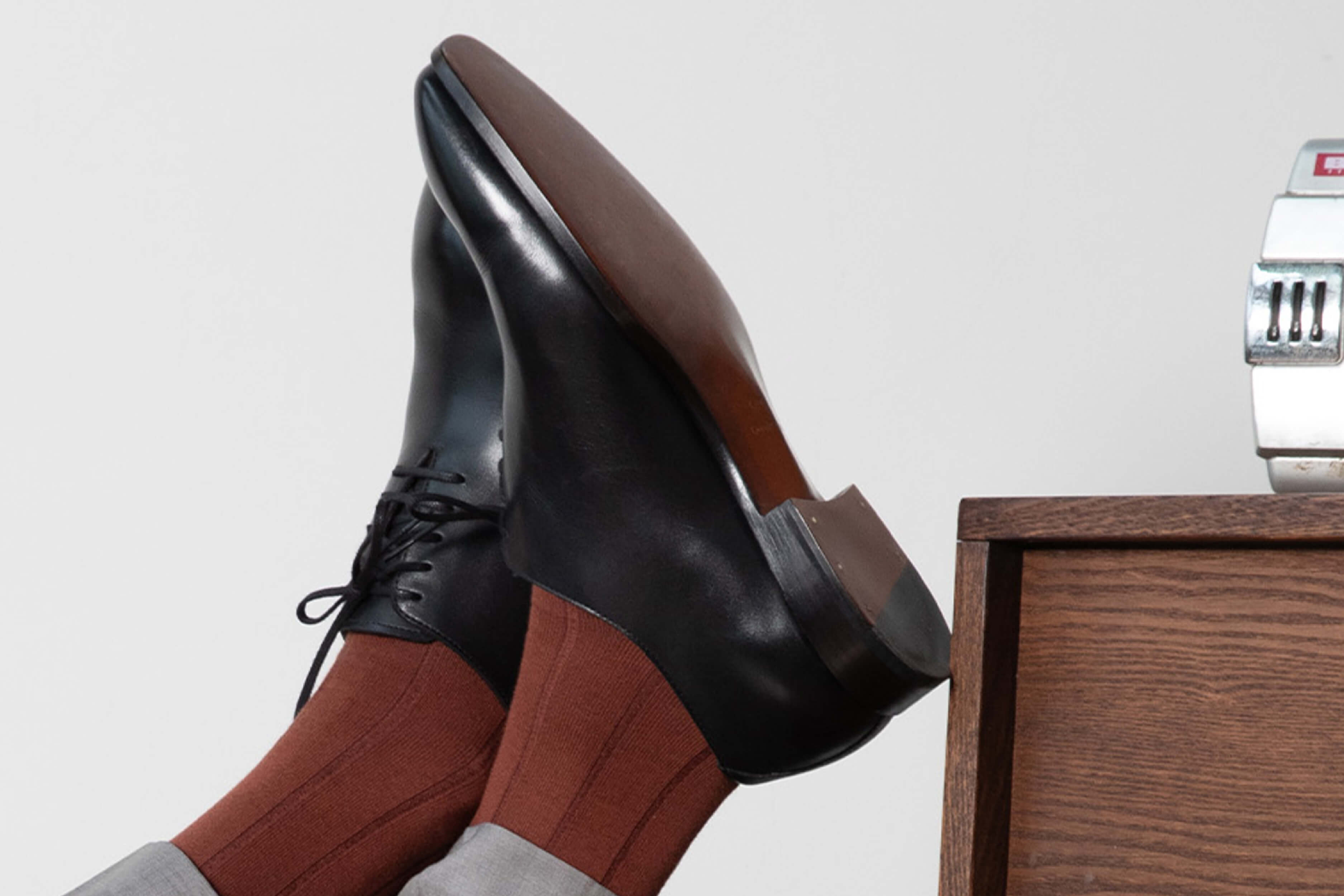 A close-up of a custom dress shoe showing the welt stitching and burnished toe